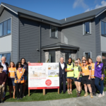 The BUILDhers crew with Prime Minister Chris Luxon and Fletcher Building chief executive Ross Taylor outside the completed house.